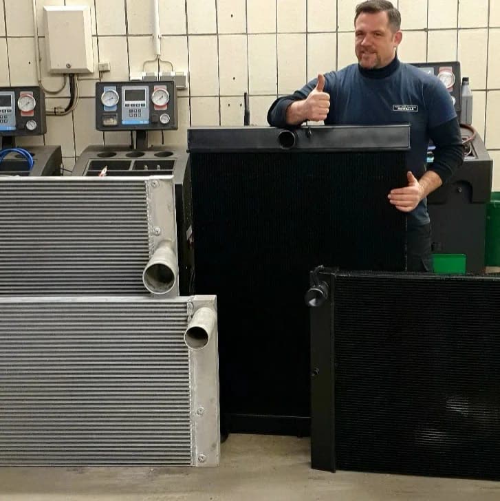 Tim Kowalla mit Kühlern in der Werkstatt, Daumen hoch