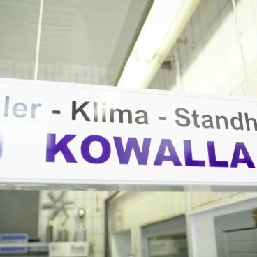Kowalla Kühler & Klimaservice: Tim Kowalla mit Schild der Werkstatt