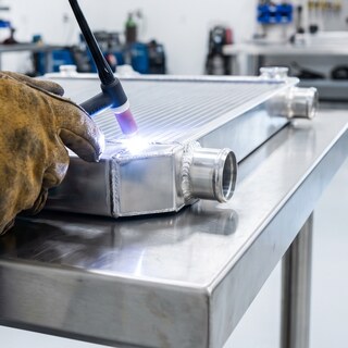 Lederstulpe und WIG-Brenner beim Schweißen an einem Aluminiumkühler